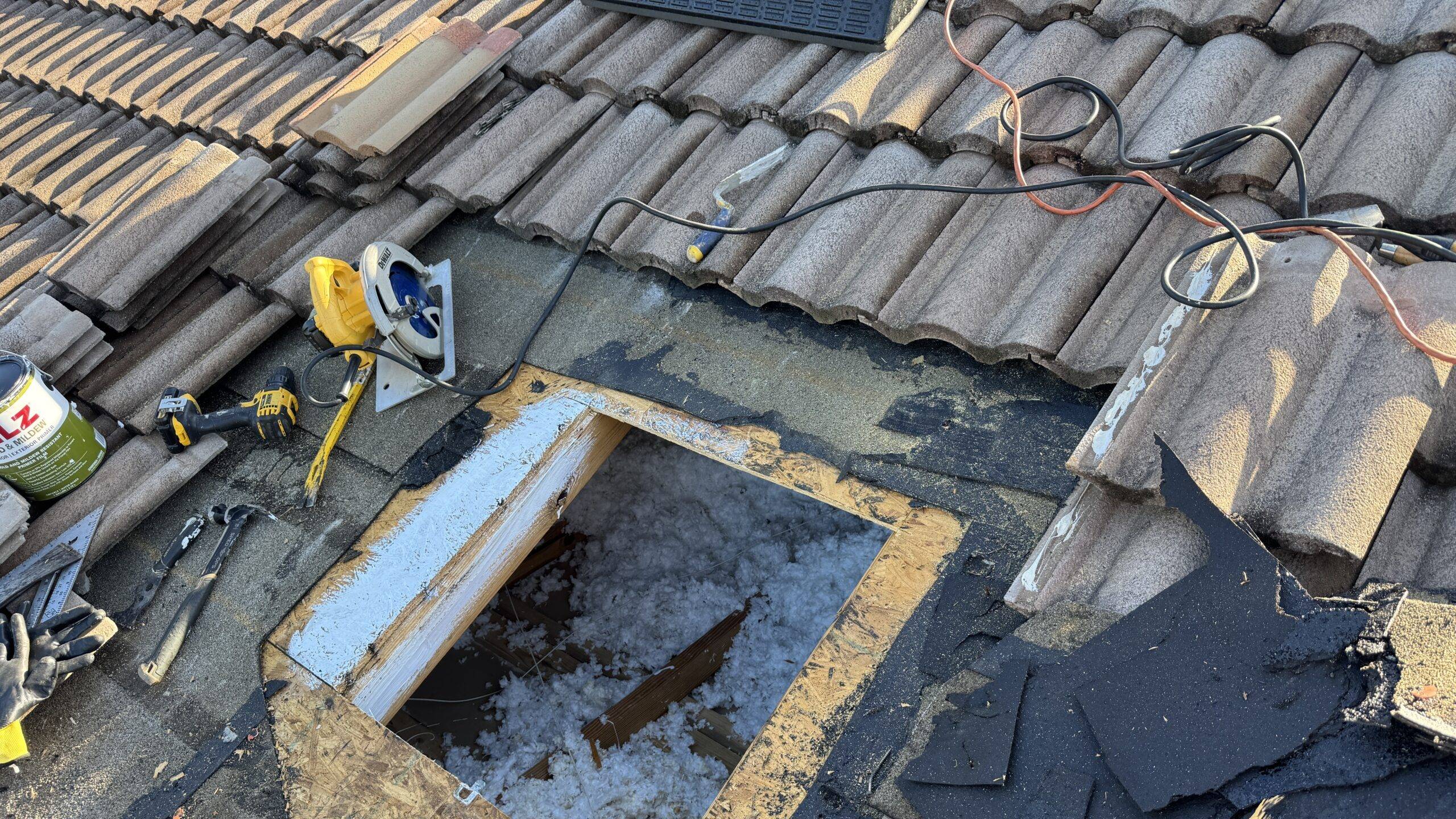 Tile roof repair showing removed tiles and exposed roof decking during leak investigation/repair
